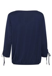 Haut bleu marine à manches longues avec une coupe ample. Présente un col rond et des accents de cordon aux manches et à l'ourlet inférieur. Texture lisse.