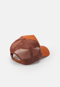 Gorra de malla marrón con un panel frontal y visera de color naranja sólido, acentuada con un botón a juego en la parte superior y una correa ajustable en la parte trasera.