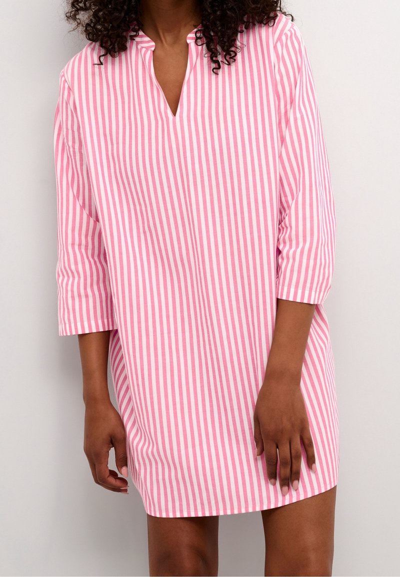 En randig skjortklänning i rosa och vitt med V-hals, 3/4 ärmar och en avslappnad passform; tillverkad av mjukt, andningsbart tyg.