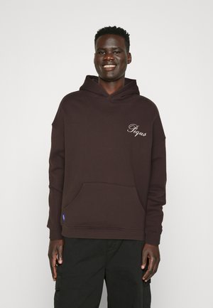 Dark brown hoodie made of textured fabric, featuring a front pocket and embroidered "Pega" logo on the chest. Loose fit with a drawstring hood.