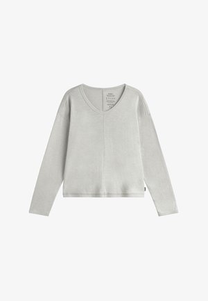 Top gris de manga larga con escote en V, que presenta un corte holgado, puños acanalados y una textura suave. Etiqueta visible en la parte posterior del escote.
