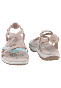 Sandales légères beiges avec plusieurs bretelles, accents turquoise, motifs géométriques sur la semelle intérieure et une semelle blanche rembourrée.