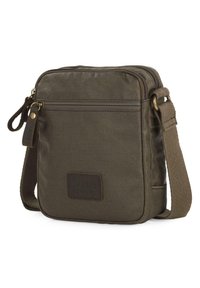 Bolso cruzado de lona verde olivo con parche de cuero, cierre de cremallera y correa ajustable; cuenta con un bolsillo frontal con cremallera.