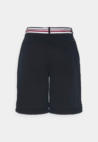 Pantalones cortos navy con una cinturilla a rayas que presenta acentos en rojo, blanco y azul. Dos bolsillos traseros, textura suave, diseño hasta la rodilla.