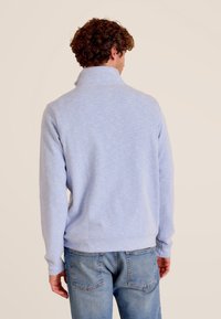 Lichtblauwe, lange mouwen pullover sweatshirt met een hoge kraag en geribde manchetten. Gladde textuur, met een subtiel gemêleerd patroon.