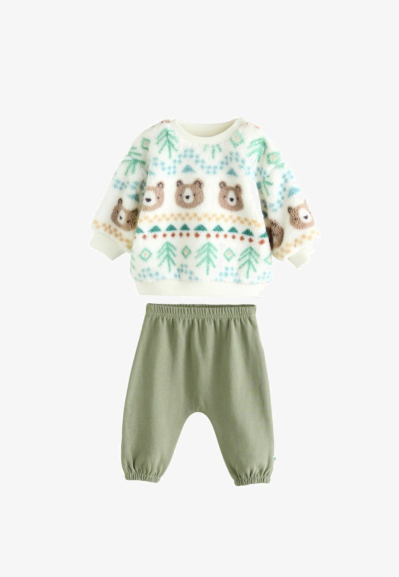 Pull en polaire avec un motif d'ours et d'arbres, couleurs crème et verte ; associé à un pantalon vert olive à taille élastique et douce.