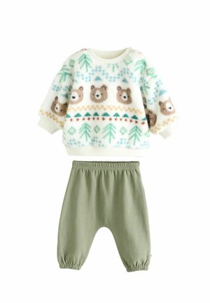Pulover din fleece cu model de urs și copaci, în culori crem și verde; asortat cu o pereche de pantaloni verzi măslinii, cu un tiv moale și elastic.