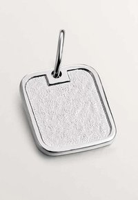 Colgante cuadrado de plata con una superficie texturizada, suspendido de un lazo ovalado pulido sobre un fondo neutro.