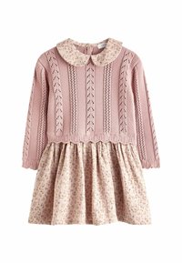 Robe en tricot rose avec une jupe à motif floral, dotée d'un col rond et de manches longues. Le corsage présente des détails verticaux et un tissu texturé.