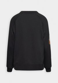 Sudadera negra con cuello redondo, mangas raglán y puños de canalé. Presenta un detalle de bordado floral en la manga izquierda.