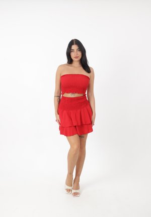Completo due pezzi rosso composto da un crop top senza spalline e arricciato e una mini gonna a strati. Tessuto liscio con orlo arricciato e vita abbinata.