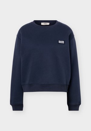 Nāvijas zila džemperis ar apaļu kaklu, garām piedurknēm un mazu kvadrātveida Mads Nørgaard logo uzšuvu kreisajā krūšu daļā.