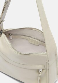 Bolso de mano de cuero de color claro con una textura suave, que cuenta con un compartimento principal con cremallera y un bolsillo adicional con una cremallera plateada.