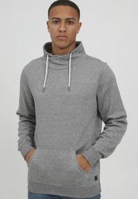 Grijze hoodie gemaakt van een zacht materiaal, met een hoge kraag, trekkoorden en een frontzak. Getextureerde stof met een ribbelzoom.
