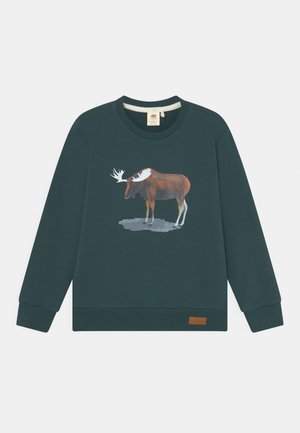 Sudadera de color verde oscuro con cuello redondo y mangas largas. Presenta un diseño de alce en colores apagados. Incluye una pequeña etiqueta marrón en el dobladillo.