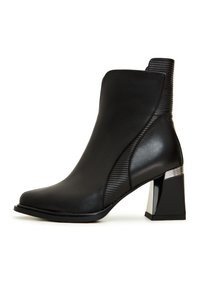 Bottine noire en cuir lisse avec un panneau latéral nervuré, dotée d'un bout carré et d'un talon bloc avec un accent métallique.
