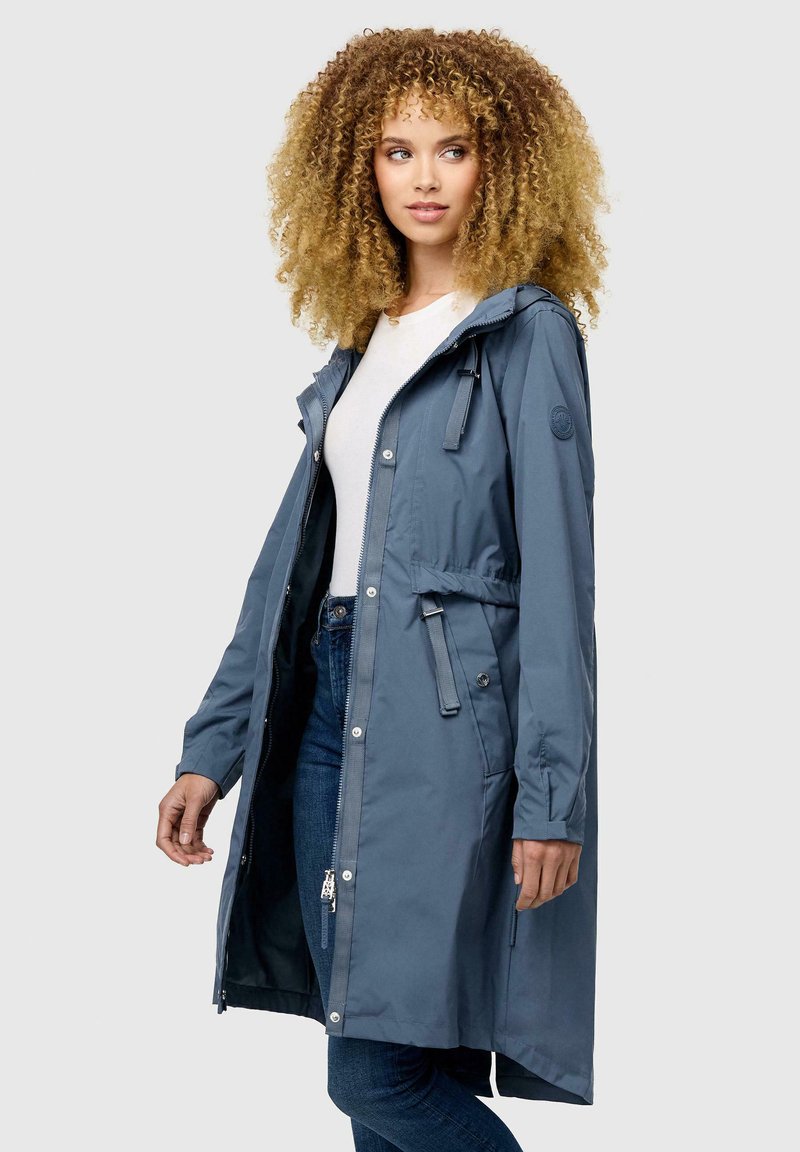Giacca blu impermeabile, lunga fino al ginocchio, con cappuccio regolabile tramite cordino, zip frontale, bottoni a pressione e vita regolabile. Texture morbida, vestibilità casual.
