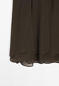 Tessuto marrone fluido con una consistenza trasparente, caratterizzato da un orlo a strati che è leggermente più lungo sul retro. Design semplice ed elegante.