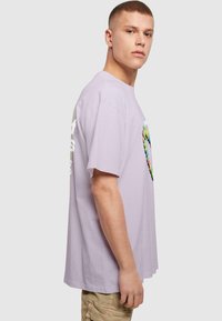 Purple cotton t-shirt with short sleeves, featuring a multicolored graphic heart design on the front. Plain back, relaxed fit.