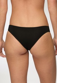 Bikini bottom in cotone nero con taglio a vita bassa, texture liscia e design minimalista. Presenta bordi puliti senza hardware visibile.