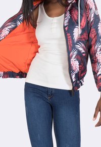 Navy and red floral bomber jacket with an orange lining, featuring a zipper, ribbed cuffs, and a lightweight, quilted texture.