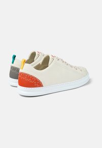 Weiße Ledersneaker mit strukturiertem Finish, ausgestattet mit einem roten und grauen Fersen Detail, kontrastierenden Schnürsenkeln und farbigen Akzenten an der Rückenschlaufe.