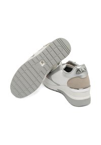 Sneaker con una combinazione di colori bianco e grigio, materiali in pelle liscia e suede, colletto imbottito, suola grigia testurizzata e dettagli metallici.