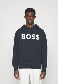 Felpa blu navy con lettering bianco "BOSS", tasca a marsupio, cappuccio regolabile con stringhe, polsini e orlo a coste. Materiale in morbido misto cotone.