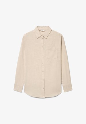 Camicia beige a maniche lunghe con bottoni, colletto e taschino sul petto, realizzata in tessuto strutturato, mostrata stesa su uno sfondo bianco.