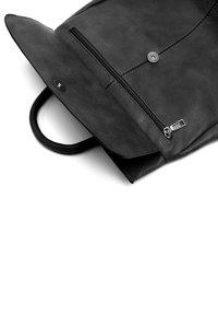 Mochila de cuero negra con un acabado texturizado, asa redondeada, bolsillo frontal con cremallera y cierre a presión. El diseño es elegante y minimalista.