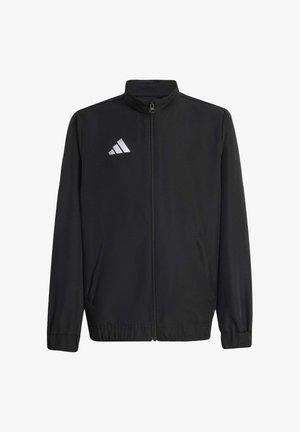 Giacca atletica nera realizzata in tessuto liscio, dotata di zip frontale, colletto alto e due tasche laterali. Logo Adidas bianco ben visibile sul petto.