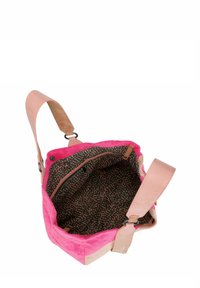 Sac à main en daim rose et beige avec une anse en cuir rose. L'intérieur présente une doublure en marron foncé avec un motif à pois et une poche zippée.