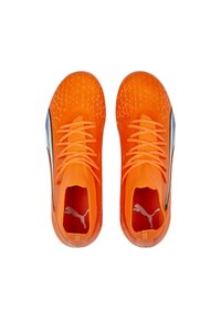 Scarpe da ginnastica di un luminoso arancione con parte superiore in rete, superficie testurizzata e lacci piatti. Presentano un accento blu e il logo Puma sul tallone.