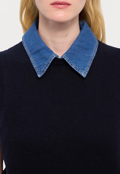 Marineblauwe gebreide trui met een denim shirtkraag. De kraag heeft dubbele stiksels met een puntig ontwerp. De textuur is glad en aansluitend.