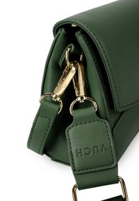 Grüne Lederhandtasche mit strukturierter Oberfläche, ausgestattet mit goldenen Beschlägen und einem abnehmbaren Schultergurt mit geprägt Logo-Details.