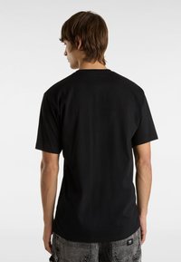 Black cotton t-shirt with short sleeves, crew neck design, and a plain back. Fabric appears smooth with a relaxed fit.