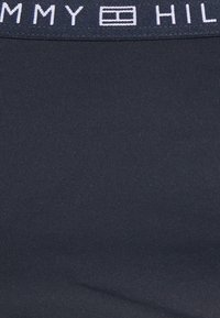 Cintura de Tommy Hilfiger em azul marinho, com texto do logótipo em branco e linhas texturizadas subtis, feita de material elástico suave.