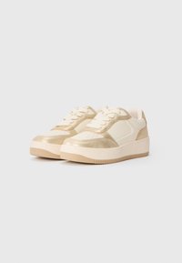 Pair of low-top sneakers in beige and metallic gold with lace-up fronts and thick rubber soles on a plain background.