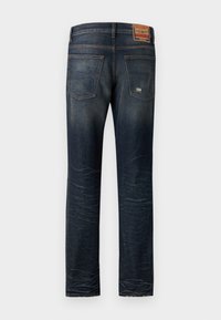 Dark blue denim jeans with a straight cut, featuring two back pockets, fading details, and a label on the waistband.