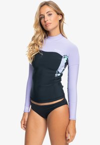 Parte superior de traje de neopreno en negro y lavanda con detalles de patrón floral en las mangas. Mangas largas, diseño ajustado, hecha de material elástico.