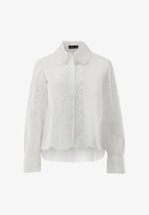 Weiße Bluse mit geschwungenem Saum, Knopfleiste und aufwändiger floraler Stickerei an Ärmeln und Körper. Lange Ärmel mit geknöpften Manschetten.