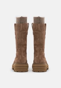 Bottes hautes en daim marron jusqu'au genou avec un tissu en tricot côtelé en haut, dotées d'une semelle en caoutchouc épaisse et texturée ainsi que de petites languettes à l'arrière.