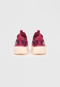 Maroone sportsko med en tekstureret overdel, tab-accents og en cremefarvet gummisål. Har et slankt, ergonomisk design.
