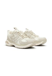 Pantofi sport bej cu panouri din plasă și sintetic, vârful rotund, talpă din cauciuc texturat și design cu șireturi. Accente de cusătură notabile.