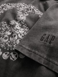 Juoda medvilninė marškinėlių su dėvėtu baltu kaukolės piešiniu ir iškilusiu "GAP" logotipu ant rankovės. Minkšta tekstūra ir laisvo stiliaus dizainas.
