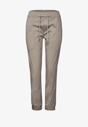 Lysbeige joggerbukser lavet af blødt stof, med en elastisk talje med snørebånd, sidelommer og elastiske manchetter ved anklerne.