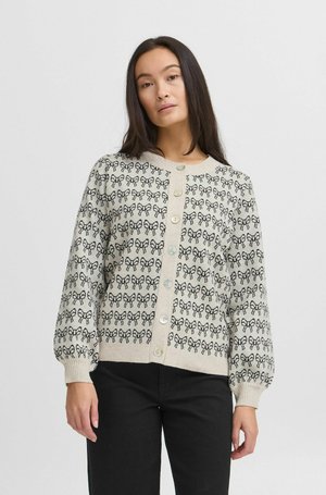 Knitted cardigan in beige with a black bow pattern, featuring a round neckline, long puffed sleeves, and button closure down the front.