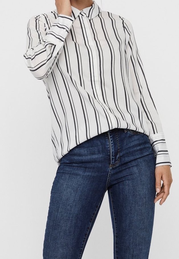 Blouse blanche à rayures noires verticales, avec col, manches longues et coupe décontractée, portée avec un jean bleu.