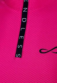 Felroze textiel met een zwarte verticale strook waarop het woord "ENDLESS" in witte letters staat en een gedeeltelijk zwart oneindigheidssymbool.