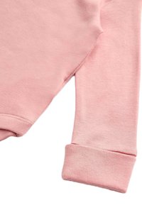 Manga de sudadera rosa claro con una textura suave y detalle de puño enrollado, que presenta un acabado liso y costuras simples.